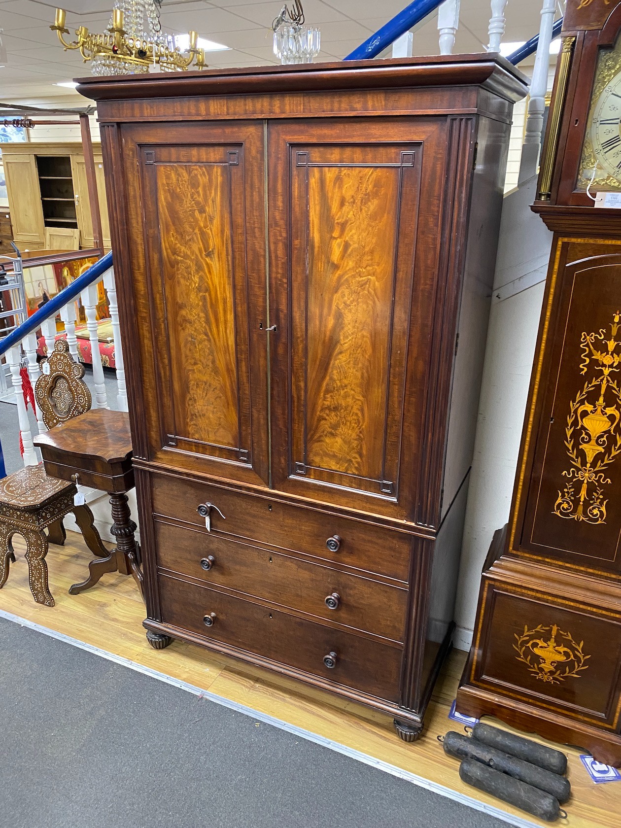 A George IV mahogany linen press of small proportions with three long drawers, width 115cm, depth 55cm, height 198cm
